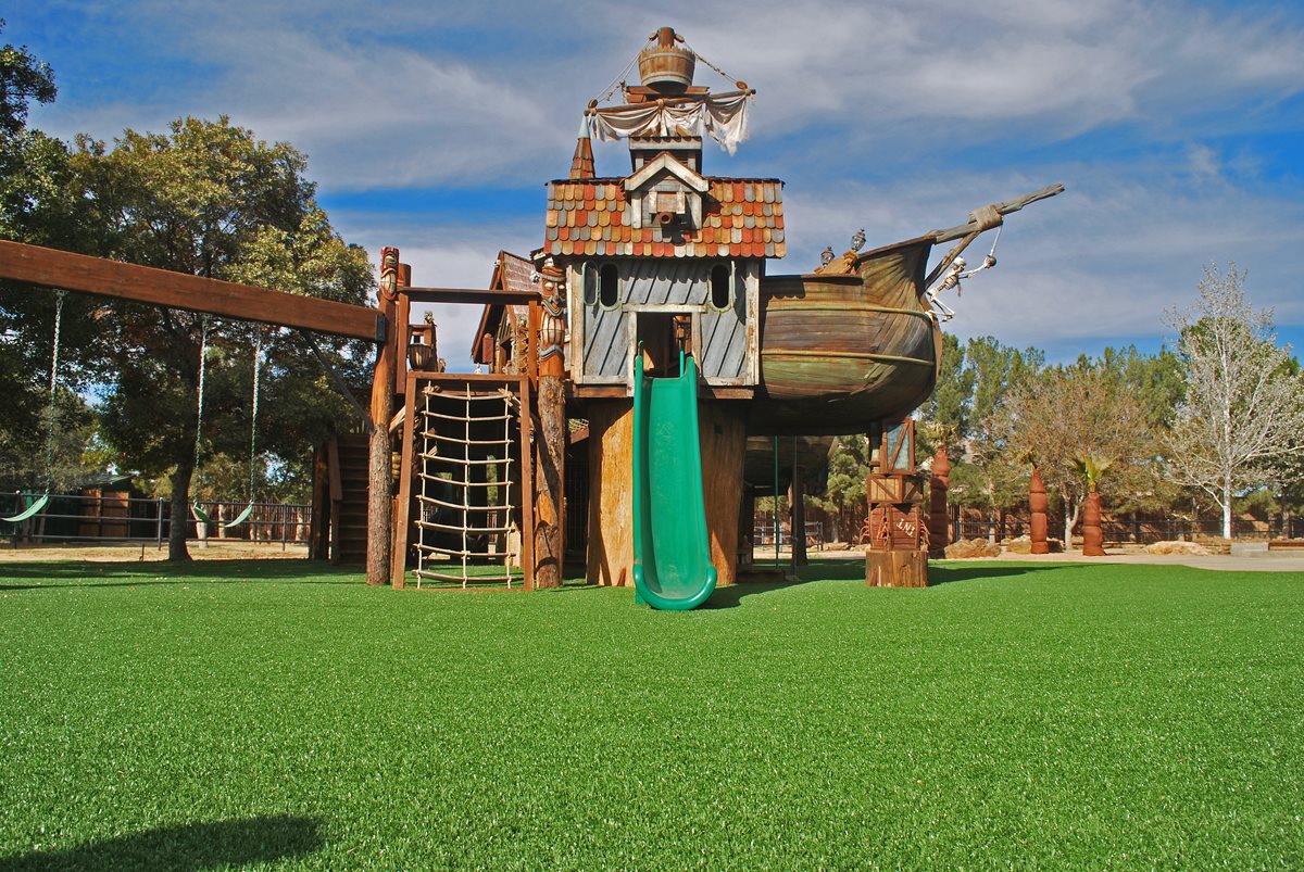 Playground equipment on top of a fall rated playground turf system installed by Southwest Greens.